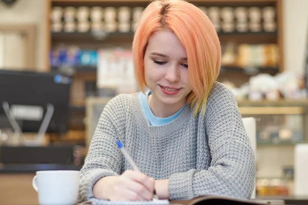 Giovane, attraente, allegro, studente ragazza amichevole seduto in un — Foto Stock