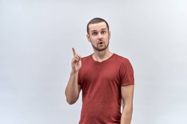 Genç kalın ifade genç adam bir parmak bir düşünceli ifade ve geniş açık gözleri ile yukarı doğru kaldırdı