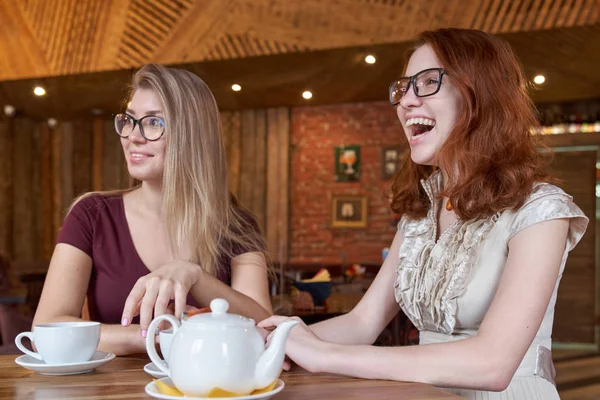 Zalotne, młoda dziewczyna, picie herbaty przy stoliku w kawiarni z entuzjazmem szczęśliwe twarze, obserwując, co dzieje się wokół. — Zdjęcie stockowe