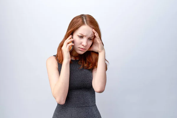 Chica joven triste cansado en vestido oscuro, sosteniendo la cabeza y hablando por teléfono. El concepto de problemas en la comunicación — Foto de Stock