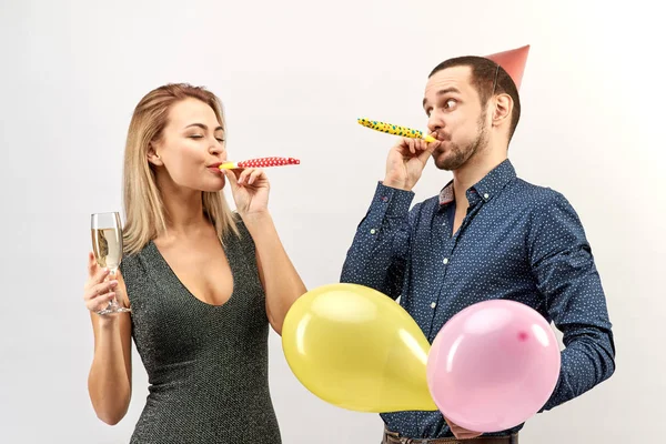 Joven pareja divertida en ropa de oficina celebrar un cumpleaños o evento corporativo, organizar una fiesta con champán, globos —  Fotos de Stock