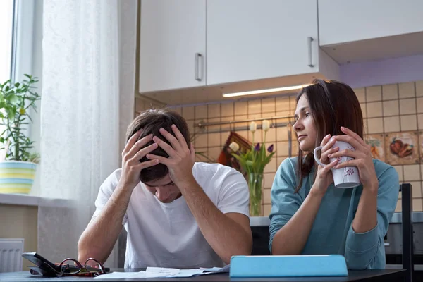 genç bir çift mutfakta bir masada oturur ve aile bütçesine analiz eder. Ailede mali kriz.