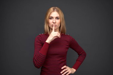 Genç şık kız ciddi ifade ile dikkatli bir şekilde gösterir değil gürültü yapmak kimseye gizli üye ve. 