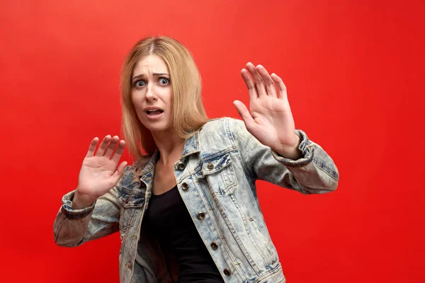 The concept of fear, horror, fright. The modern young lady in fear tries to fence off her hands, with a frightened face — Stock Photo, Image