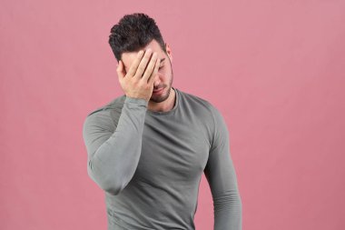 Genç spor adamı utanç, başarısızlık ve baş ağrısı bir işareti olarak yüz onun palm basar. Negatif duygular, ruh hali ve motivasyon.