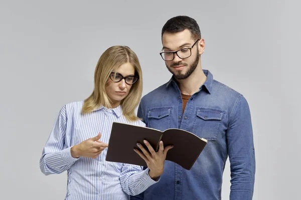 Una giovane coppia in occhiali e abbigliamento business un uomo e una donna in lavoro insieme al progetto e con un sorriso che studia i dati . — Foto Stock