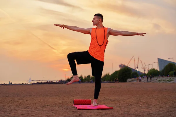 Atlético homem fazendo ioga asanas na natureza, areia do mar — Fotografia de Stock
