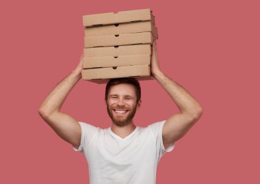 Kurye, duvarda izole edilmiş bir sürü pizza kutusu tutuyor.