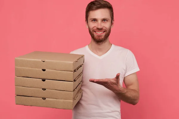 Courier holds many pizza boxes isolated on wall