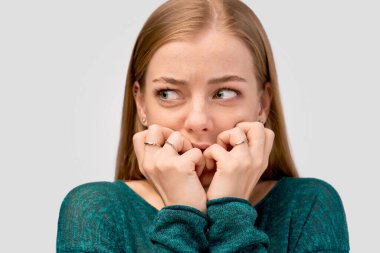 Kızıl saçlı, yeşil gözlü, süveter giyen kız.