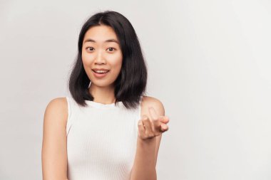 Gülümseyen genç kadın kameraya işaret ediyor