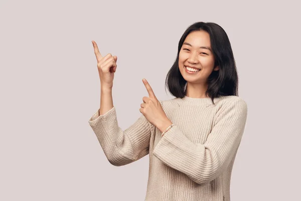 Leende flicka visar fingret åt sidan och upp — Stockfoto