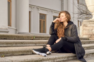 Düşünceli kız çenesini tutarak boş alana bakıyor.. 