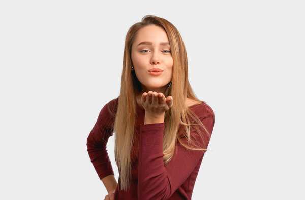 Portrait of cute lovely girl sending blowing kiss with pout lips looking at camera
