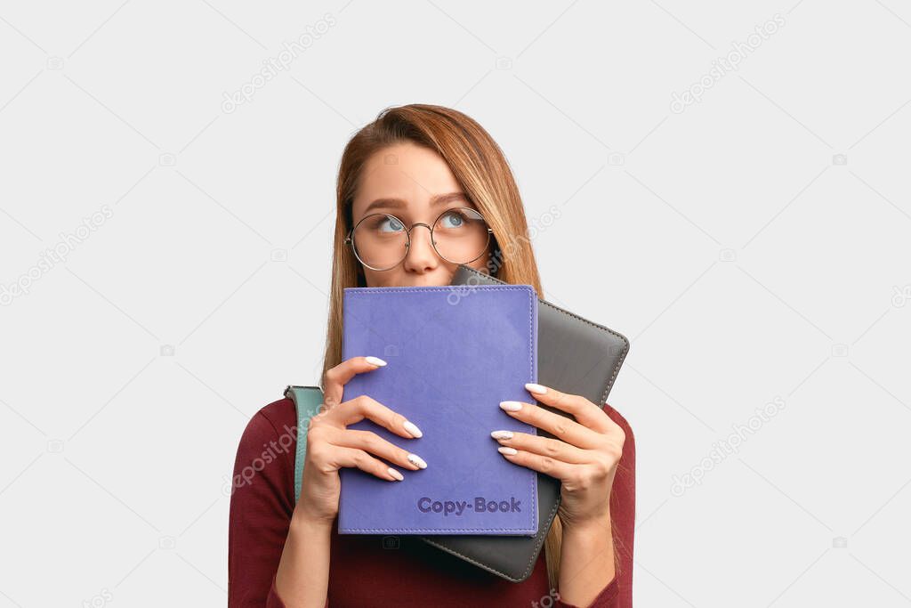 Student looks up, hiding behind books in Studio 