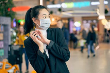 Kadın virüse karşı korumak için tıbbi maske takıyor.