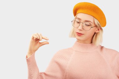 Smiling girl shows little amount of something