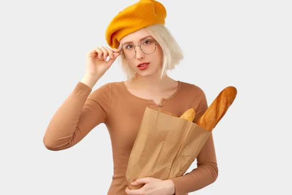 Ung kvinna som håller i en påse med baguette. — Stockfoto