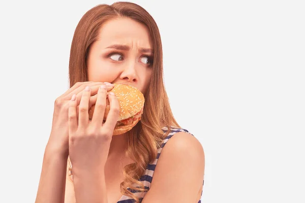 Girl quickly eats Burger, afraid of being caught — Stockfoto