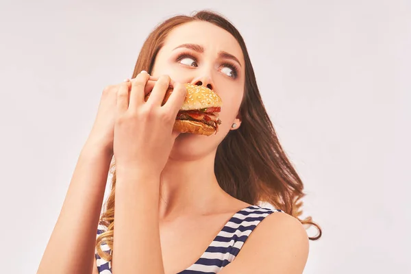 Girl quickly eats Burger, afraid of being caught — Stockfoto