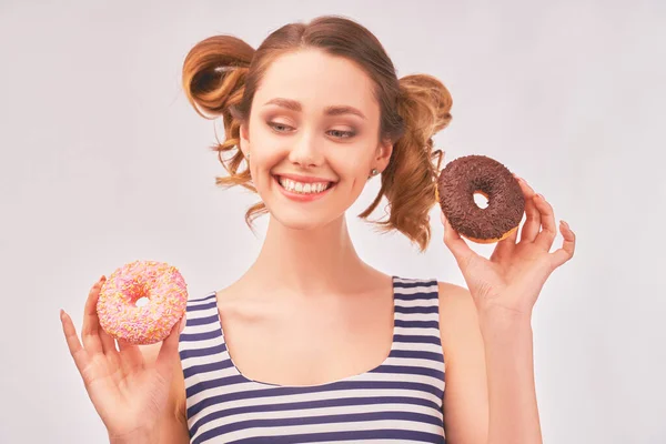 Happy girl holds donut and chews mouth full — Stockfoto