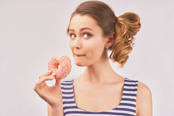 Happy girl holds donut and chews mouth full — Stockfoto