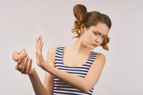 Happy girl holds donut and chews mouth full — Stockfoto