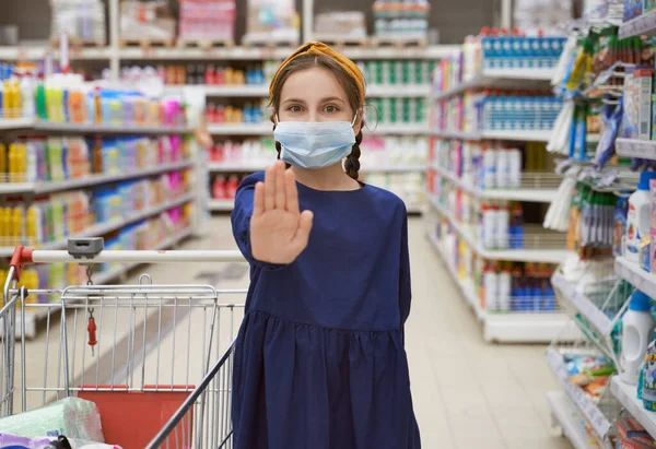 Gadis bertopeng medis mencapai tangan menunjukkan tanda berhenti — Stok Foto