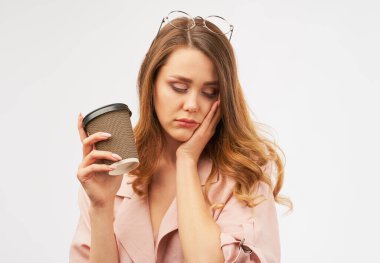 Kadın ofis çalışanı elinde bir fincan kahve tutuyor. 