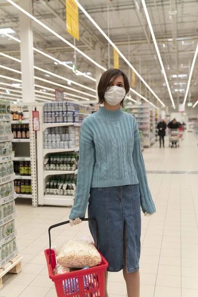 Chica en máscara médica hace que el mercado de productos de stock —  Fotos de Stock