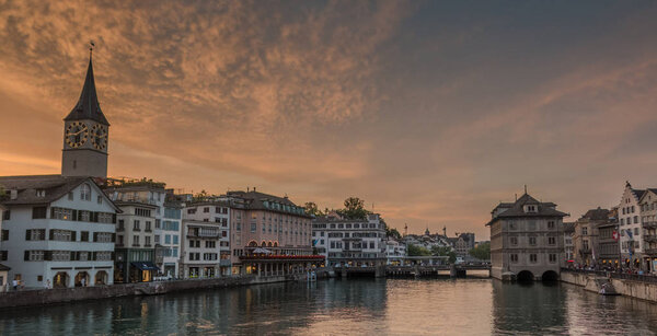 A picture of the Limmat river and its adjacent buildings in the sunset.