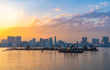 Tokyo Körfezi 'nde gün batımında sergilenen Olimpiyat Halkaları' nın bir resmi..