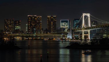 Tokyo Körfezi 'nde, beyazla aydınlatılmış Gökkuşağı Köprüsü' nün bir resmi.).
