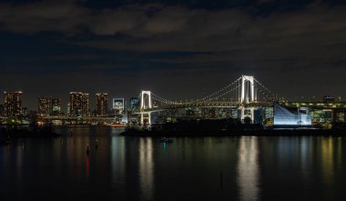 Tokyo Körfezi 'nde, beyazla aydınlatılmış Gökkuşağı Köprüsü' nün bir resmi.).