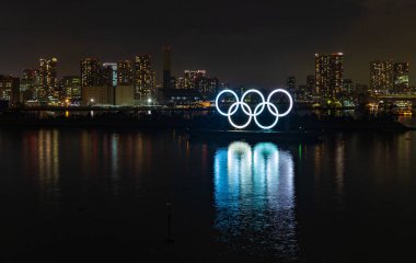 Tokyo Körfezi 'nde geceleri sergilenen aydınlatılmış Olimpiyat Halkaları' nın bir resmi..