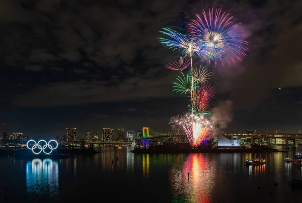 Tokyo Körfezi 'ndeki Olimpiyat Halkaları' nın açılışını anan havai fişeklerin bir resmi.).