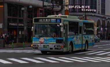 Kyoto 'da bir kavşaktan geçen bir kamu otobüsünün resmi.