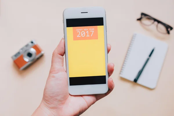 Hand holding smartphone with 2017 on screen — Stock Photo, Image