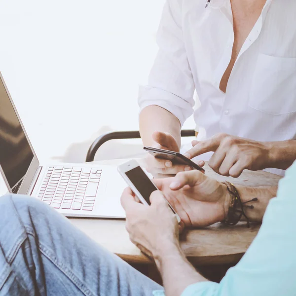 Two businessmen meeting and using smartphone