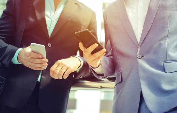 Dos hombres de negocios usando teléfonos inteligentes — Foto de Stock