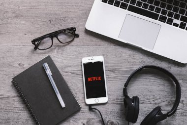 Bangkok, Tayland - 28 Nisan 2018: En iyi görünümü Netflix app simgesi kulaklık ve dizüstü bilgisayar ile iphone ekranında. Netflix film ve Tv dizisi izlemek için bir uluslararası önemli abonelik hizmetidir.