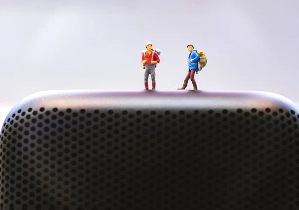 Pessoas viajante em miniatura na mochila em pé em alto-falante, música — Fotografia de Stock