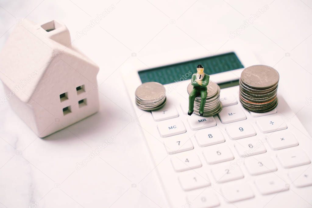 Miniature business people figure sitting on stack of coins on ca
