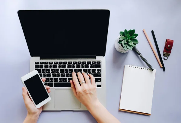 Platte lay-out van werkruimte bureau met vrouw handen typen op laptop en — Stockfoto