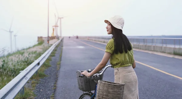 Young asian millennial woman with bicycle feeling relax while traveling in countryside, spring and summer holiday, banner style