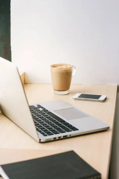 Workspace in cafe with computer laptop and latte coffee and smartphone, lifestyle and business concept