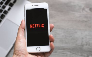 BANGKOK, THAILAND - 28 Nisan 2018: evde otururken Netflix uygulamasını iPhone akıllı telefon ekranında izlemek. Netflix, film ve televizyon dizileri için uluslararası bir abonelik serisidir.