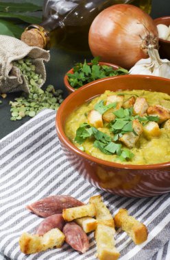 Rustik kase taze yeşil yaprakları ile süslenmiş split bezelye çorbası,