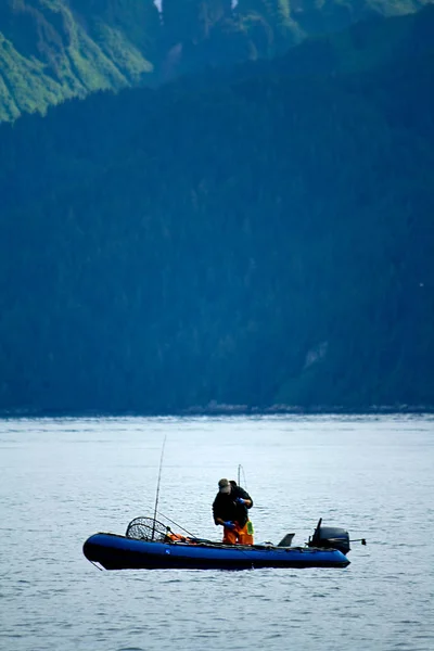 Uomo che pesca sulla barca gonfiabile in Alaska — Foto Stock