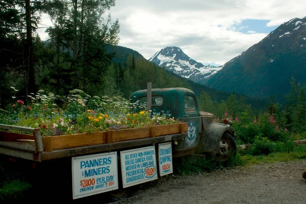 Caminhão velho com flores em cama e sinais em Alaska — Fotografia de Stock